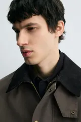 Cazadora de corte relajado confeccionada en tejido técnico con algodón. Presenta cuello de solapa en pana a contraste, cierre frontal con cremallera oculta por solapa con botones a presión, bolsillos de vivo en la cadera y manga larga.