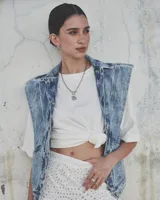 Collar de cadena de eslabones alargados con cierre frontal tipo T y dije circular de textura rústica e irregular.