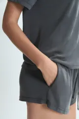 Short de descanso color gris, con cintura elástica y cordón ajustable. Presenta un diseño holgado y cómodo.