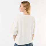 Remera oversize blanca de manga corta, con cuello redondo y estampa frontal estilo vintage que incluye un vaso de bebida y la inscripción "Matcha Lover Club".