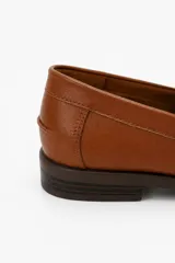 Mocasín de símil cuero negro con silueta clásica, costuras marcadas y tira sobre el empeine.