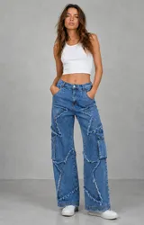 Jean de tiro medio con corte wide leg, confeccionado en denim azul. Presenta un diseño distintivo con apliques en forma de estrella con bordes deshilachados y bolsillos laterales tipo cargo.