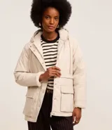 Campera parka color beige, forrada con peluche sintético, confeccionada en poliuretano. Tiene capucha, ajuste en el cuello, cierre delantero, bolsillos delanteros con solapa y textura gomosa.