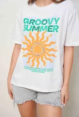 Remeron de algodón blanco con diseño estampado frontal que incluye un sol naranja, texto en tonos verdes y detalles de apliques brillantes.