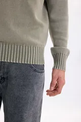 Buzo tejido lavado de color verde militar, con cuello redondo, mangas largas y puños y cintura de rib elástico.