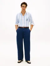 Camisa de corte clásico de puro algodón Oxford, con diseño de rayas verticales en color celeste y blanco. Cuenta con cuello abotonado, bolsillo frontal de parche con un escudo bordado y mangas largas con puños redondeados.