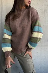 Sweater de tejido de punto con cuerpo en color marrón y mangas con diseño de rayas horizontales en tonos verde, turquesa y crema. Presenta cuello redondo y puños acanalados.