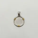 Dije circular de diseño minimalista, fabricado en plata 925 con acabado satinado en el centro y detalles decorativos en oro en tres puntos del borde.
