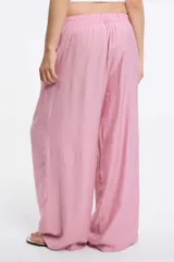 Pantalón de corte amplio y pierna recta, confeccionado en tela texturizada color rosa. Presenta cintura elastizada con cordón ajustable y bolsillos laterales.