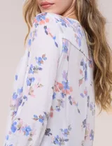 Blusa de gasa Zac & Rachel con estampado de rayas verticales en tonos rosados, amarillos y blancos. Presenta escote en V con cuello mao, cierre frontal con botones, un bolsillo aplicado en el pecho, mangas largas con presilla para regular el largo y detalle de nudo en el dobladillo inferior.