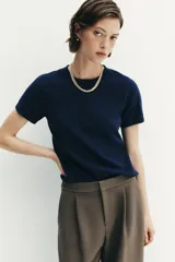 Jersey de punto de cuello redondo y manga corta, con diseño minimalista y textura suave.