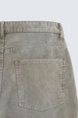 Pantalón de pana de corte flare, color verde oliva desgastado, con cinco bolsillos y cierre frontal de cremallera y botón.