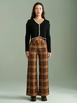 Saco de algodón negro con aberturas en hombros y codos, corte entallado, cuello en V y botones pequeños.