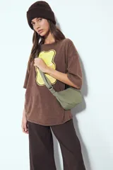 Remera de corte oversize con efecto desgastado (washed), manga corta y cuello redondo. Presenta una estampa gráfica central de un oso de goma (gummy bear) en tonos amarillos.