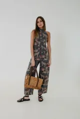 Cartera tipo tote bag de tamaño pequeño, confeccionada en cuero con estampado animal print. Presenta detalles en cuero color chocolate en las manijas y terminaciones internas. Incluye cierre metálico superior para mayor seguridad.