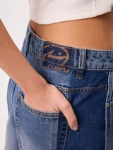 Jeans wide leg de tiro medio con diseño de pierna ancha, lavado azul claro en el frente y franjas laterales en tono azul oscuro contrastante. Confeccionado en algodón.