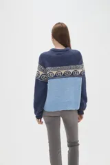 Sweater de tejido de punto con diseño jacquard, cuello redondo y mangas largas. Presenta una combinación de bloques de color azul marino y celeste con un patrón geométrico en la parte superior.