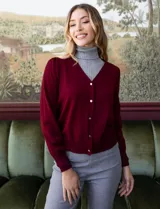 Cárdigan tejido en hilado fino color borgoña, con escote en V y cierre frontal con botones metálicos dorados. Mangas largas con leve frunce en los hombros.