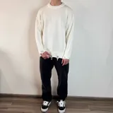 Sweater de tejido de punto color blanco, con diseño de cuello redondo y detalles de roturas desgastadas en el cuello, puños y ruedo.