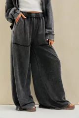 Pantalon de jogging negro con efecto acid wash, corte ancho y fluido, tiro alto con cintura elastizada fruncida y bolsillos frontales aplicados.