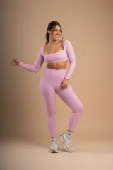 Conjunto deportivo color rosa compuesto por un top de mangas largas con escote cuadrado y calzas de tiro alto.