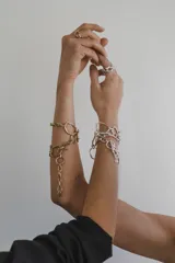 Collar de cadena con eslabones irregulares de diseño artesanal, con cierre frontal tipo barra y aro. La pieza permite diversas formas de uso, incluyendo como collar, pulsera o accesorio de espalda.