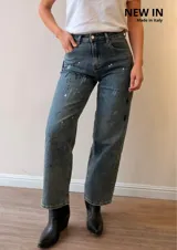 Jeans mom fit de tiro alto y pierna relajada, en tono denim envejecido con matices gris-azulados. Presenta un diseño exclusivo con efecto de pinceladas y salpicaduras artísticas, bolsillos delanteros y traseros, y costuras reforzadas.