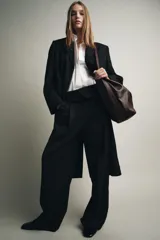 Bolso tipo saca confeccionado en piel, con diseño de doble compartimento interior, asa de hombro y bolsillo interno con cierre de cremallera.
