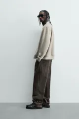 Cazadora bomber negra de corte regular fit, confeccionada en tejido efecto ante. Cuenta con cuello, puños y bajo en rib elástico, manga larga, bolsillos de vivo en la cadera y un bolsillo interior. Cierre frontal con cremallera.