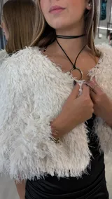 Chaqueta corta de textura peluda en color blanco, con diseño de manga larga y frente abierto.
