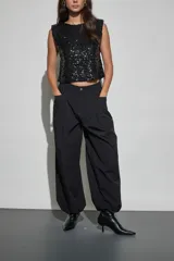 Pantalon negro de corte holgado y estilo cargo, con cintura elástica, bolsillos laterales y terminación ajustada en los tobillos.