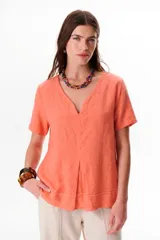 Blusa de lino color salmón, con escote en V, mangas cortas y detalle de pliegues en el frente.