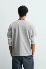Camiseta de corte boxy fit, con cuello redondo y manga corta. Presenta un acabado irregular con efecto lavado que le otorga un aspecto vintage.
