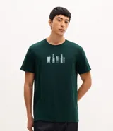 Remera de algodón color verde oscuro con cuello redondo y manga corta. Presenta una estampa frontal pequeña y centrada con ilustraciones de vasos y botellas de cerveza junto a la frase 'Out of office'.