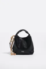 Bolso mini Bimba Y Lola modelo Paper, de cuero negro con diseño suave y asa de mano integrada. Cuenta con detalles de cuerda beige con nudos en el lateral y el logo de la marca impreso en plateado en la parte frontal.