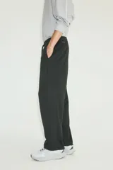Jogger deportivo H&M de corte relajado, color negro, confeccionado en tejido funcional con tecnología DryMove. Cuenta con cintura elástica con cordón de ajuste, bolsillos laterales y diseño de piernas rectas.