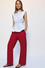 Camisa de algodón sin mangas con cuello solapa, diseño a rayas celestes y blancas, pliegues en la cintura y bajo evasé. Cierre frontal con botones ocultos.