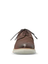 Zapato de estilo casual con cordones, confeccionado en cuero marrón con detalles de perforaciones decorativas tipo brogue. Cuenta con una suela de EVA flexible y ligera en color gris claro con un pequeño detalle naranja en el lateral.