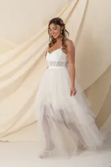 Vestido largo de tul color marfil, con corsé con ballenas y cintura transparente, breteles finos y falda de tul en capas.