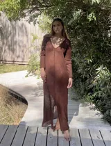 Vestido largo color crudo, de tejido de algodón fino y ligero, con escote en V y mangas largas acampanadas. Se puede usar con el escote hacia adelante o hacia atrás.