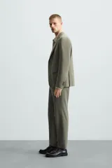 Pantalón de vestir regular fit confeccionado en tejido con lana, con bolsillos frontales y traseros de doble vivo con botón, cierre frontal con cremallera y botón.