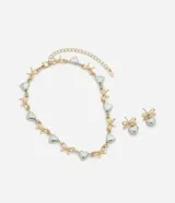 Conjunto de collar corto y aros tipo caravanas, con diseño de dijes alternados de lazos dorados y corazones plateados.