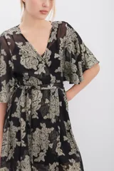 Vestido largo de viscosa con jacquard de flores en lurex dorado. Presenta escote en V cruzado, mangas al codo y elástico en la cintura con lazo ajustable. Incluye un viso al tono con breteles regulables.