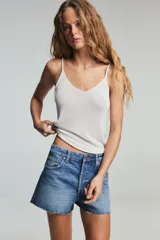 Shorts de jean de tiro bajo con diseño de cinco bolsillos, cintura con trabillas y cierre frontal con cremallera y botón metálico.