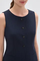 Chaleco sin mangas de corte sastrero, color marrón con diseño de rayas verticales finas. Presenta cuello redondo, cierre frontal con botones y dos bolsillos laterales simulados.