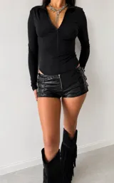 Body negro de manga larga con cuello mao, cierre frontal con cremallera y diseño ajustado.