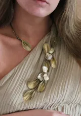 Gargantilla de bronce con dije de hoja y collar con dije de hojas y piedras de nácar.