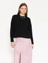 Sweater negro de lana merino con fit holgado, largo a la cadera y mangas largas.