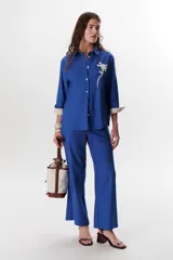 Pantalón de lino color verde militar, de corte recto y tiro alto, con cintura ajustable mediante cordón.