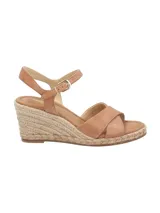 Sandalias con plataforma de yute color marrón claro, con dos tiras anchas cruzadas de cuero marrón y pulsera al tobillo con hebilla dorada.